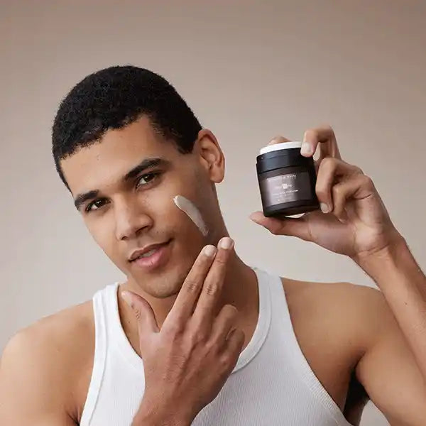 Woman applying cream to skin