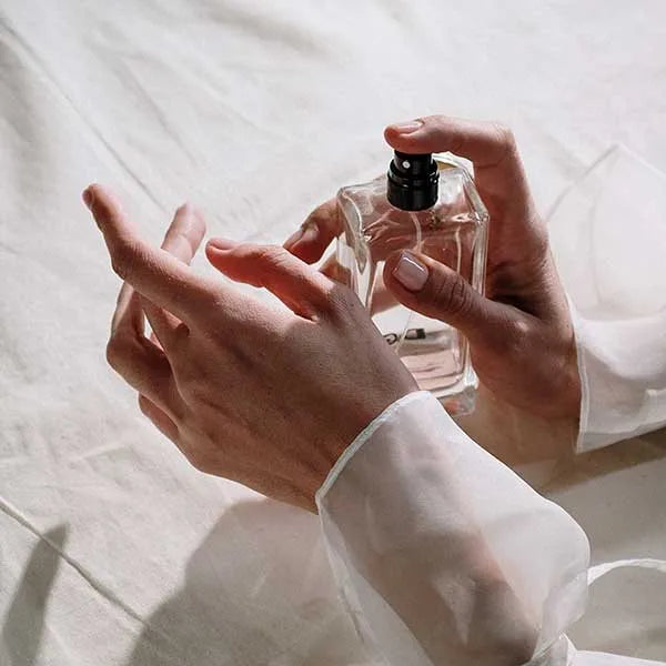 Woman applying perfume to wrists