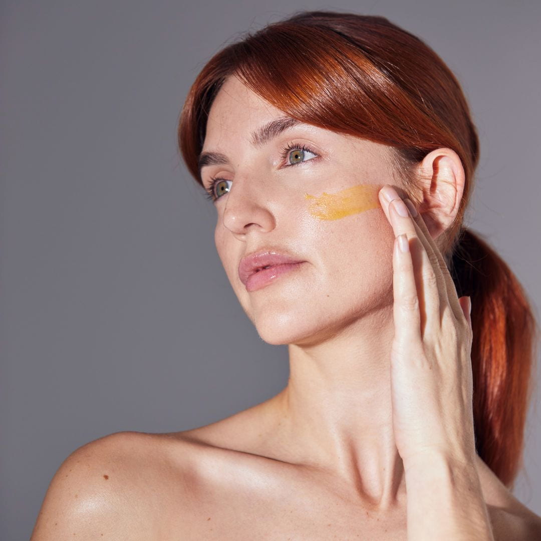 Skincare model applying skincare to cheek