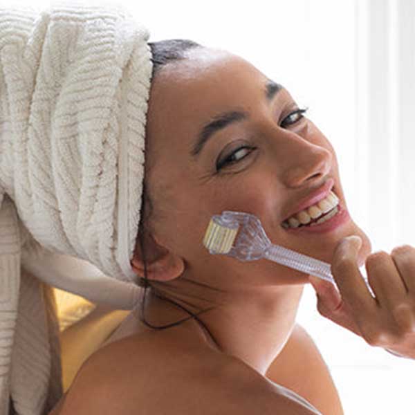 Woman using Synergie Skin Home Roller needling device