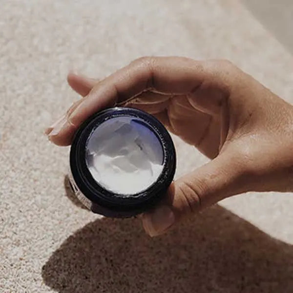 Woman holding jar with skin product inside